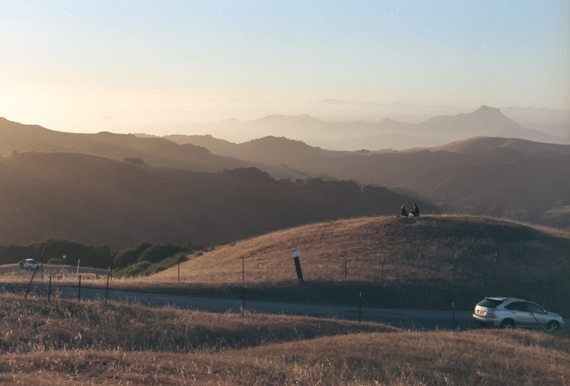 marine layer washes over hills at prefumo canyon san luis obispo california, people sit on a blanket atop a hill, 35mm film