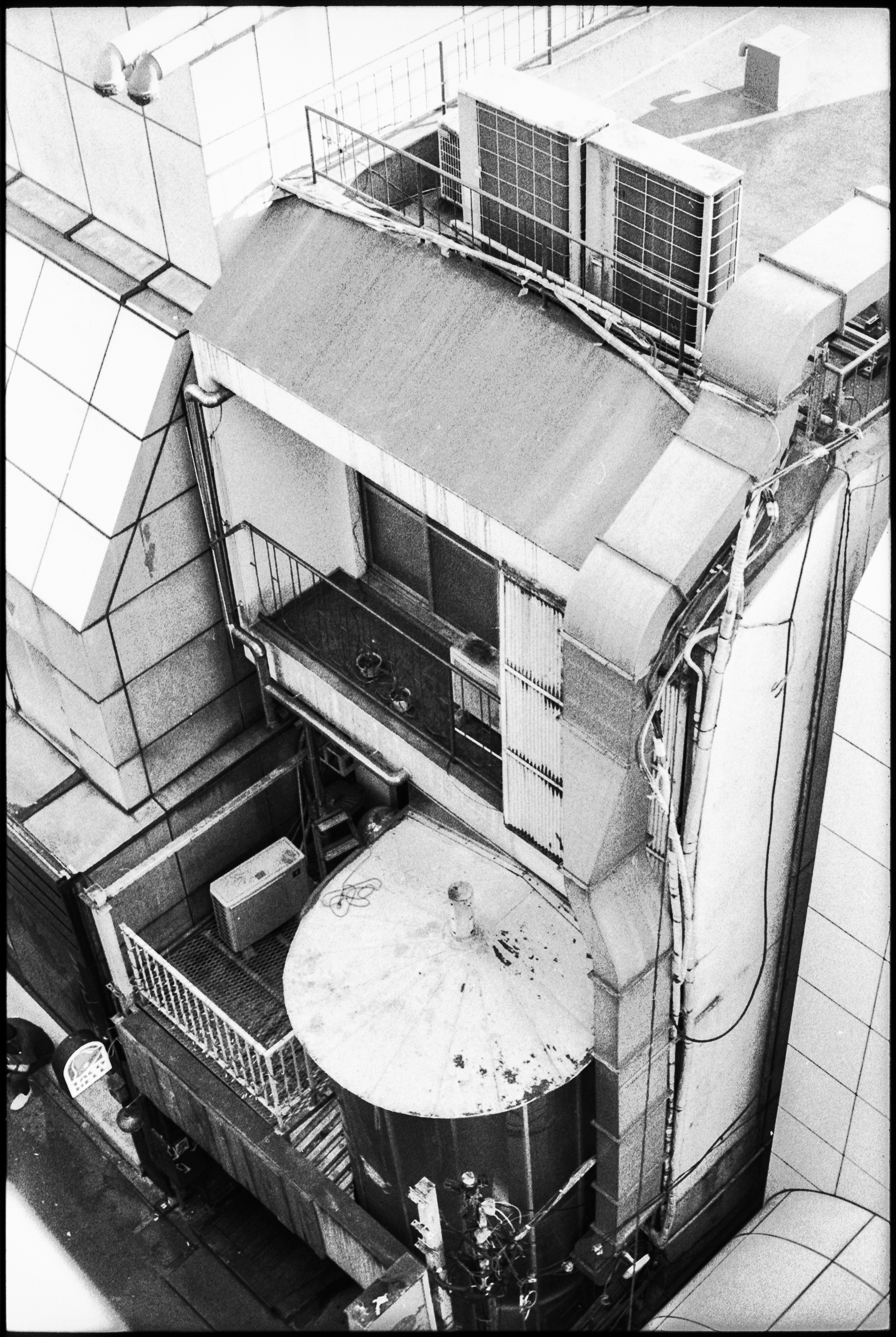 rooftop air conditioning units seen from above on densely stacked apartments in japan, 35mm black and white film