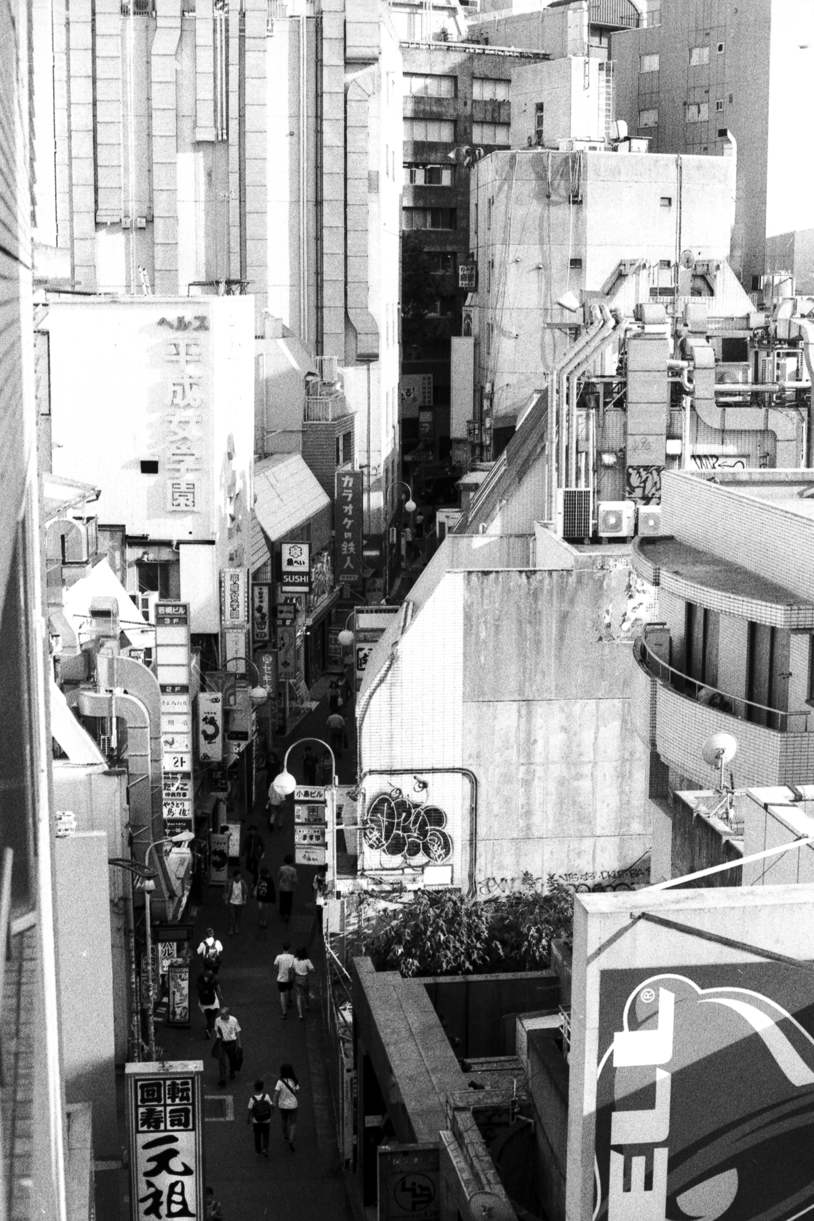 busy japanese urban side street seen from above, 35mm black and white film