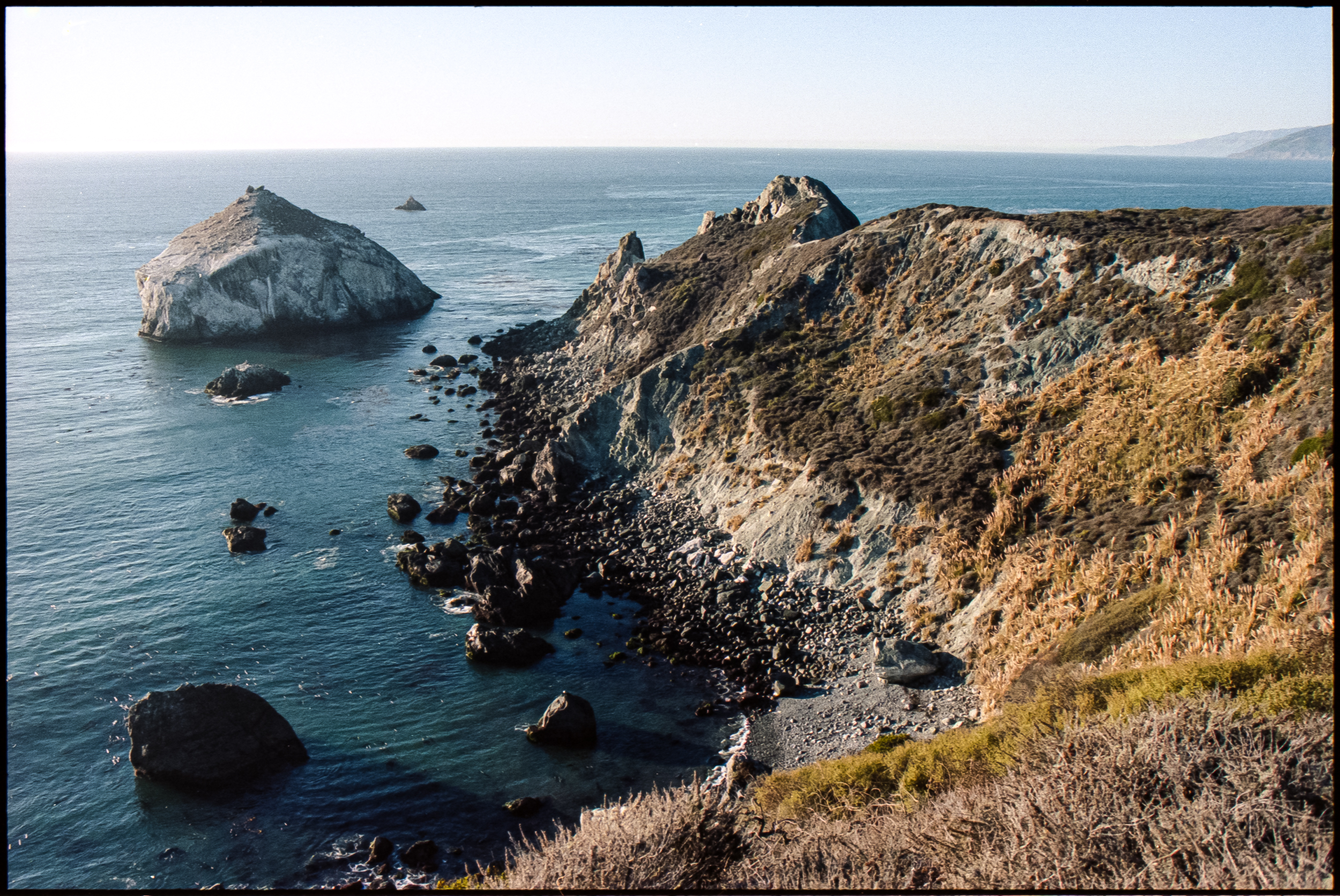 pacific coast with offshore rock formations visible from pch highway, 35mm film