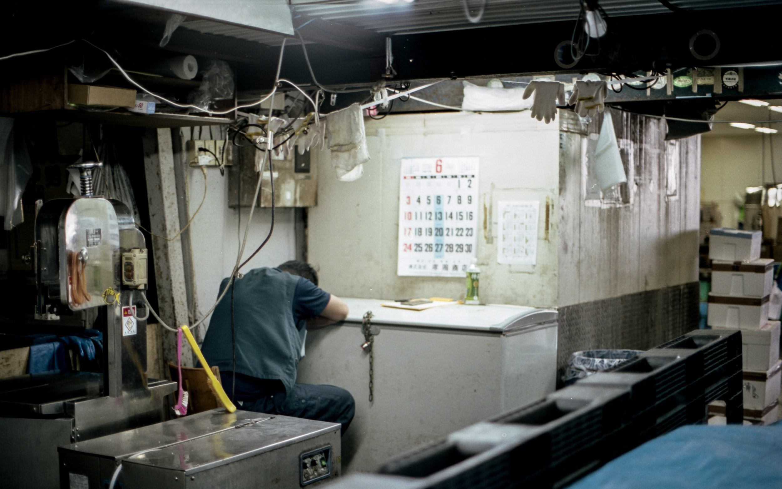 man taking a nap at workstation in tsukiji fish market, japan, 35mm film