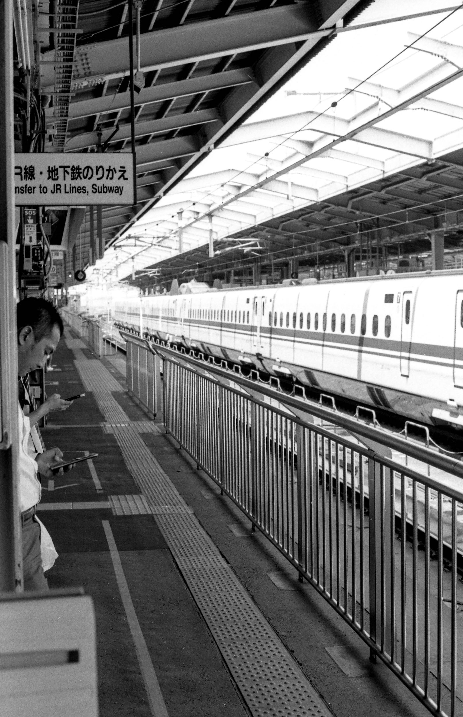passengers line up awaiting train at japanese station, 35mm black and white film