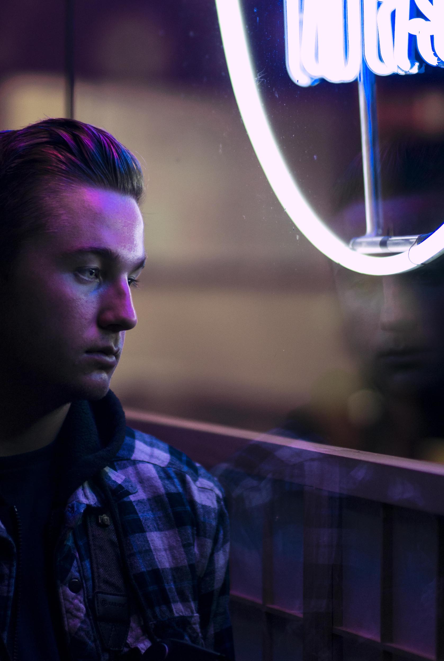 moody portrait in front of neon sign, night