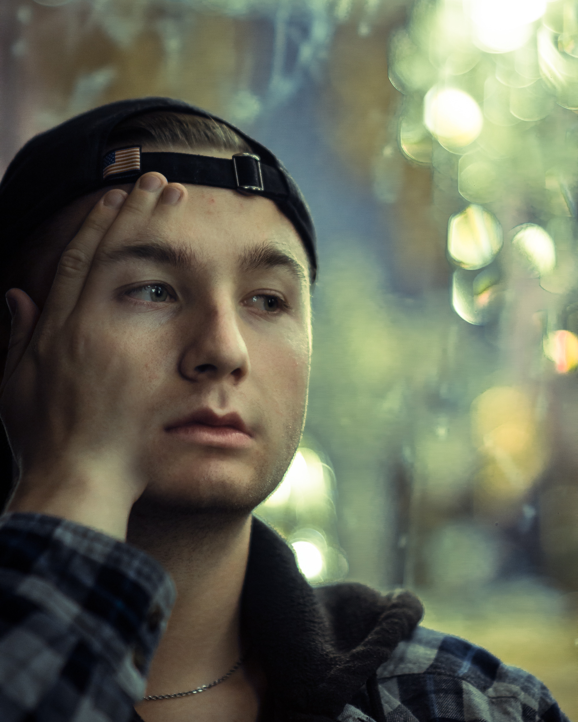 a male figure with a solemn expression with his hand melting into the surface of his face