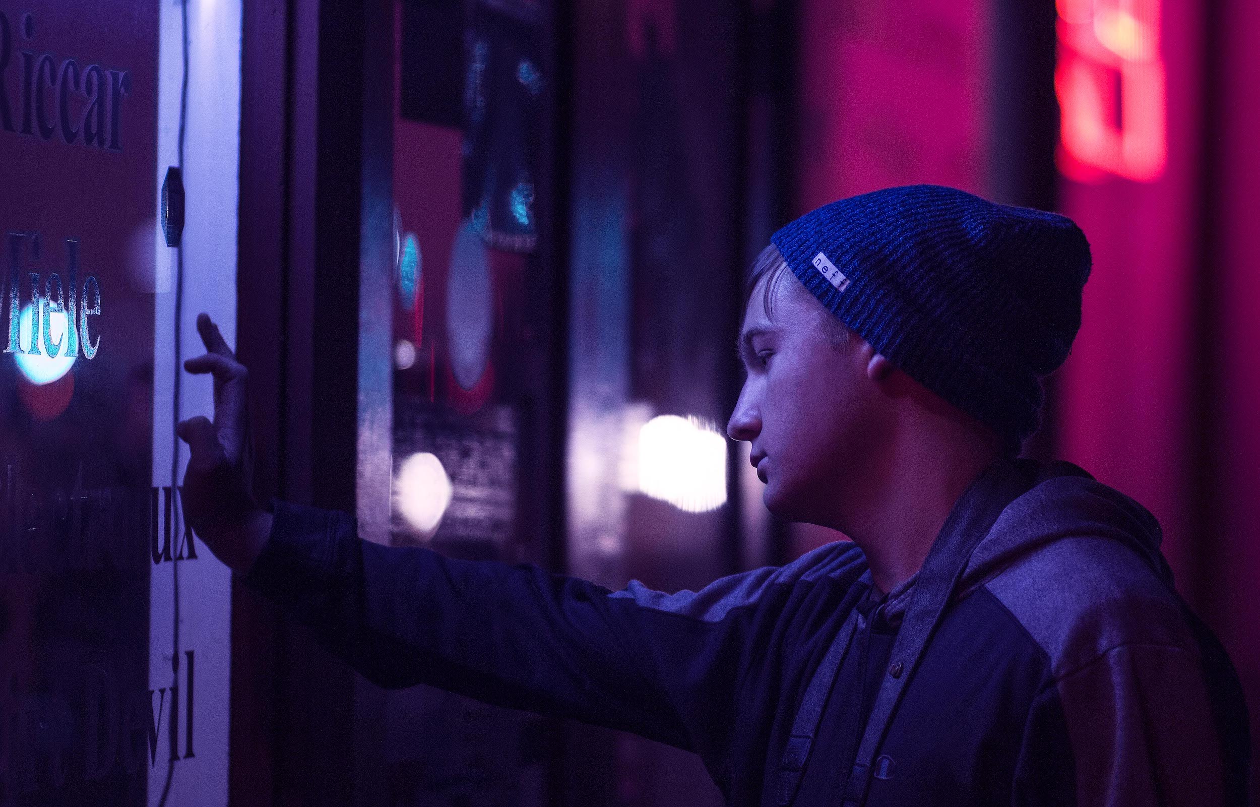 moody portrait in front of neon sign, night