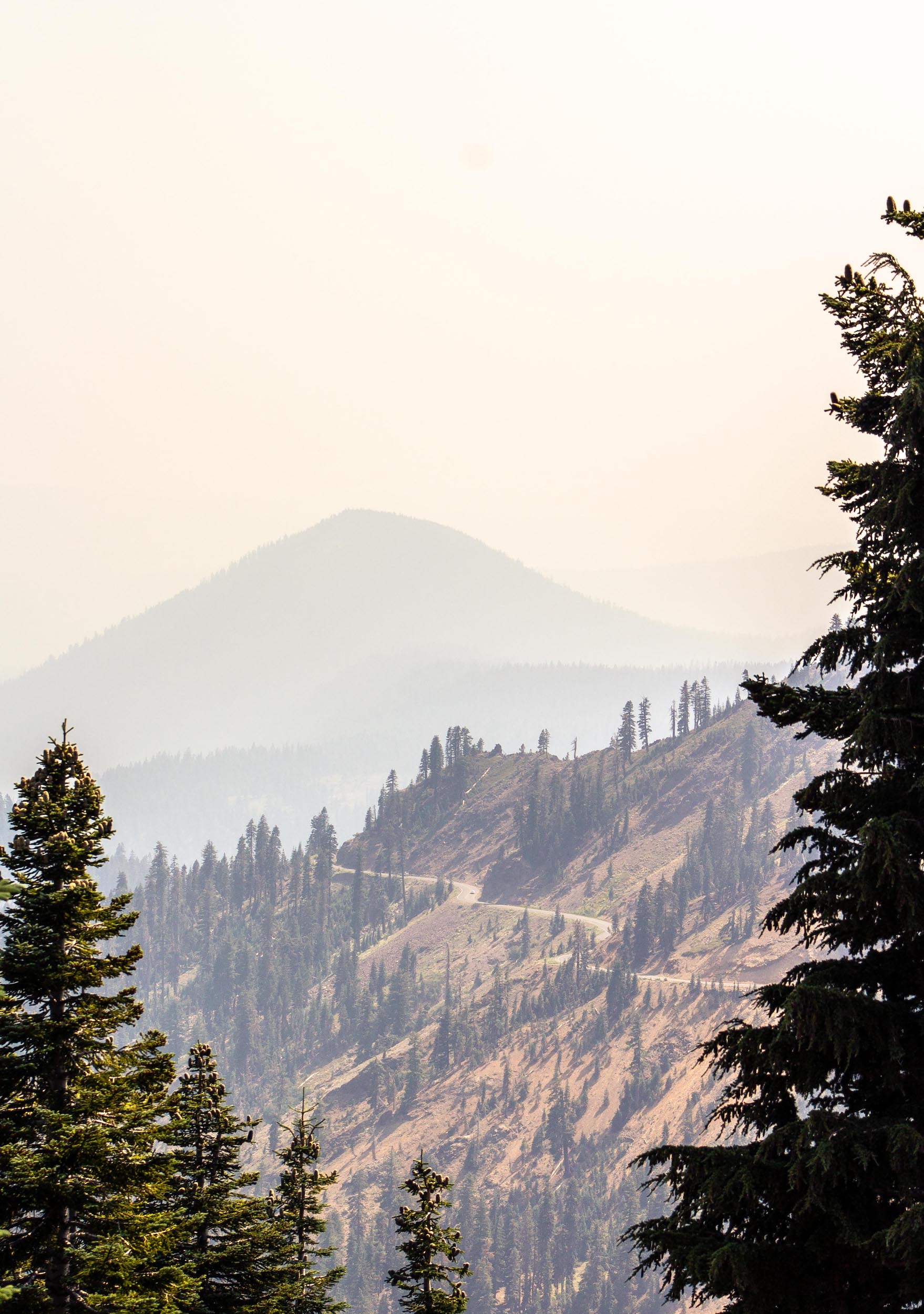 winding mountain road in front of distant peak, mount lassen volcanic national park california